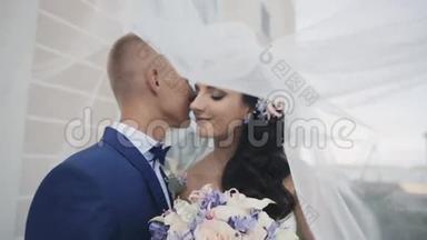 新娘和新郎戴着婚纱。 相爱的一对夫妇在一起的时间很温柔。 结婚那天男人和女人接吻。